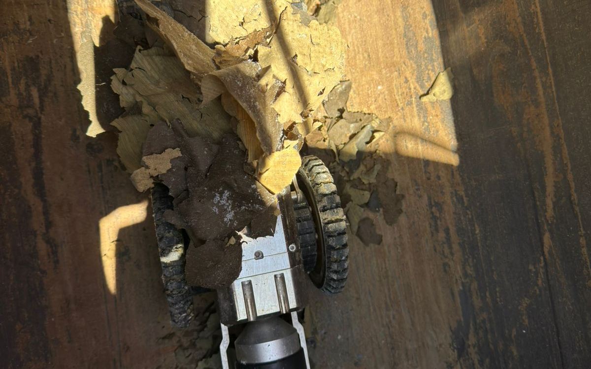 Robot crawler avanzando dentro de un ducto con residuos y desprendimientos